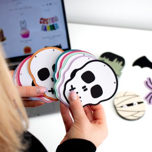 Holding halloween skull garland party decoration with colourful outline in studio